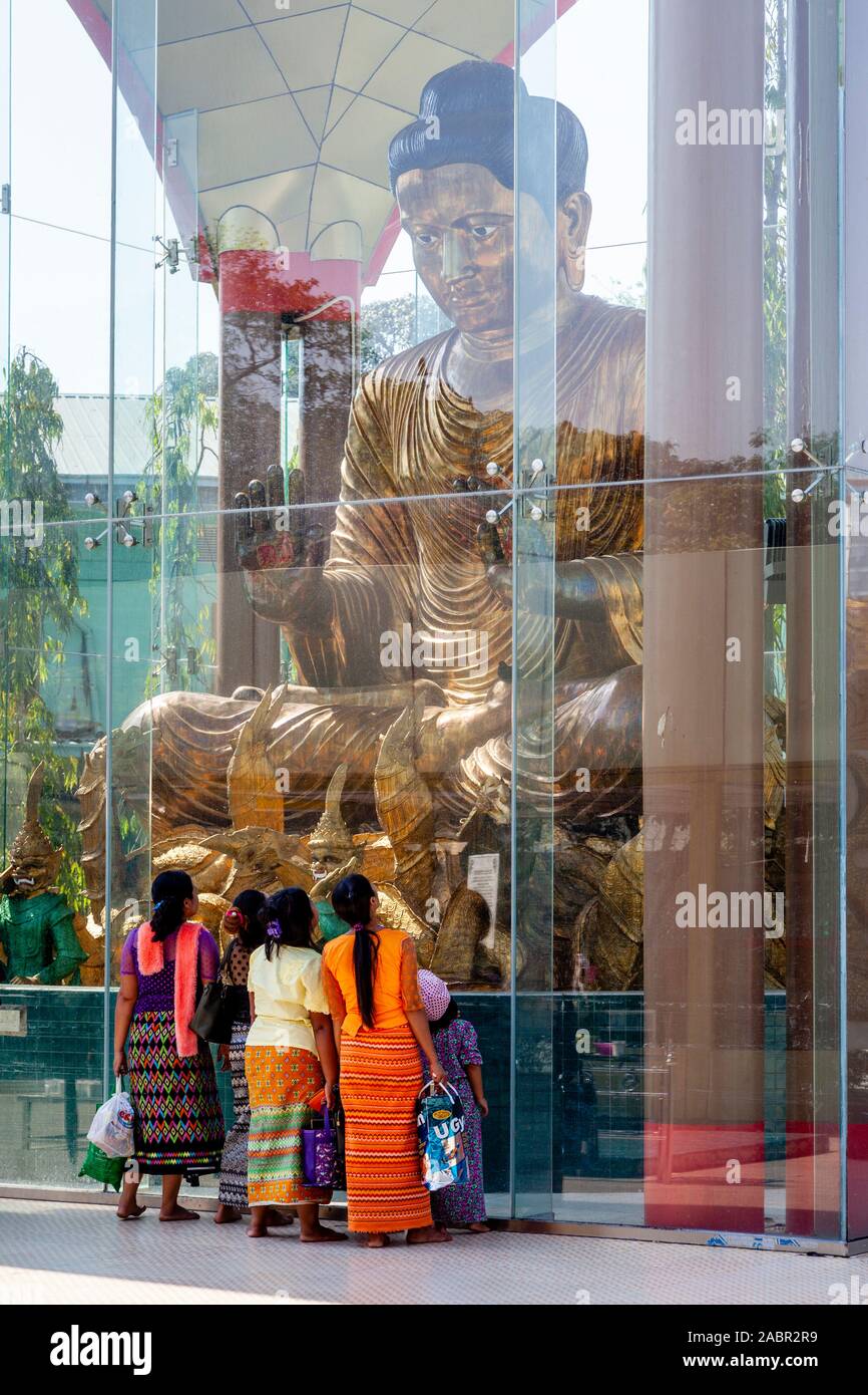 Un groupe de femmes birmanes à à une statue bouddhique, Botahtaung Paya Botataung (), Yangon, Myanmar. Banque D'Images