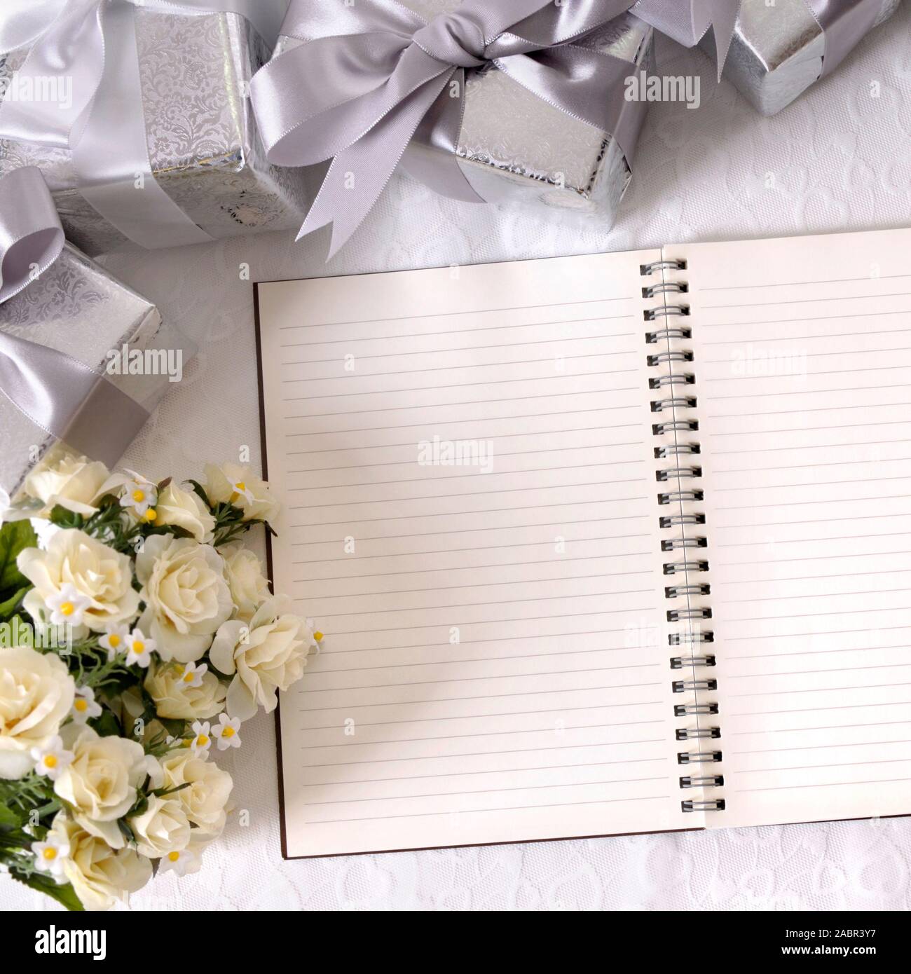 Arrière-plan de mariage avec carnet et un stylo posé sur la dentelle mariée avec plusieurs cadeaux de mariage d'argent et rose bouquet. L'espace pour copier. Banque D'Images Arrière-plan de mariage avec carnet et un stylo posé sur la dentelle mariée avec plusieurs cadeaux de mariage d'argent et rose bouquet. L'espace pour copier. Banque D'Images