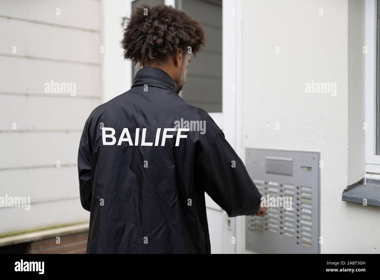 Homme debout à l'entrée de la Chambre, la sonnerie Sonnette Banque D'Images