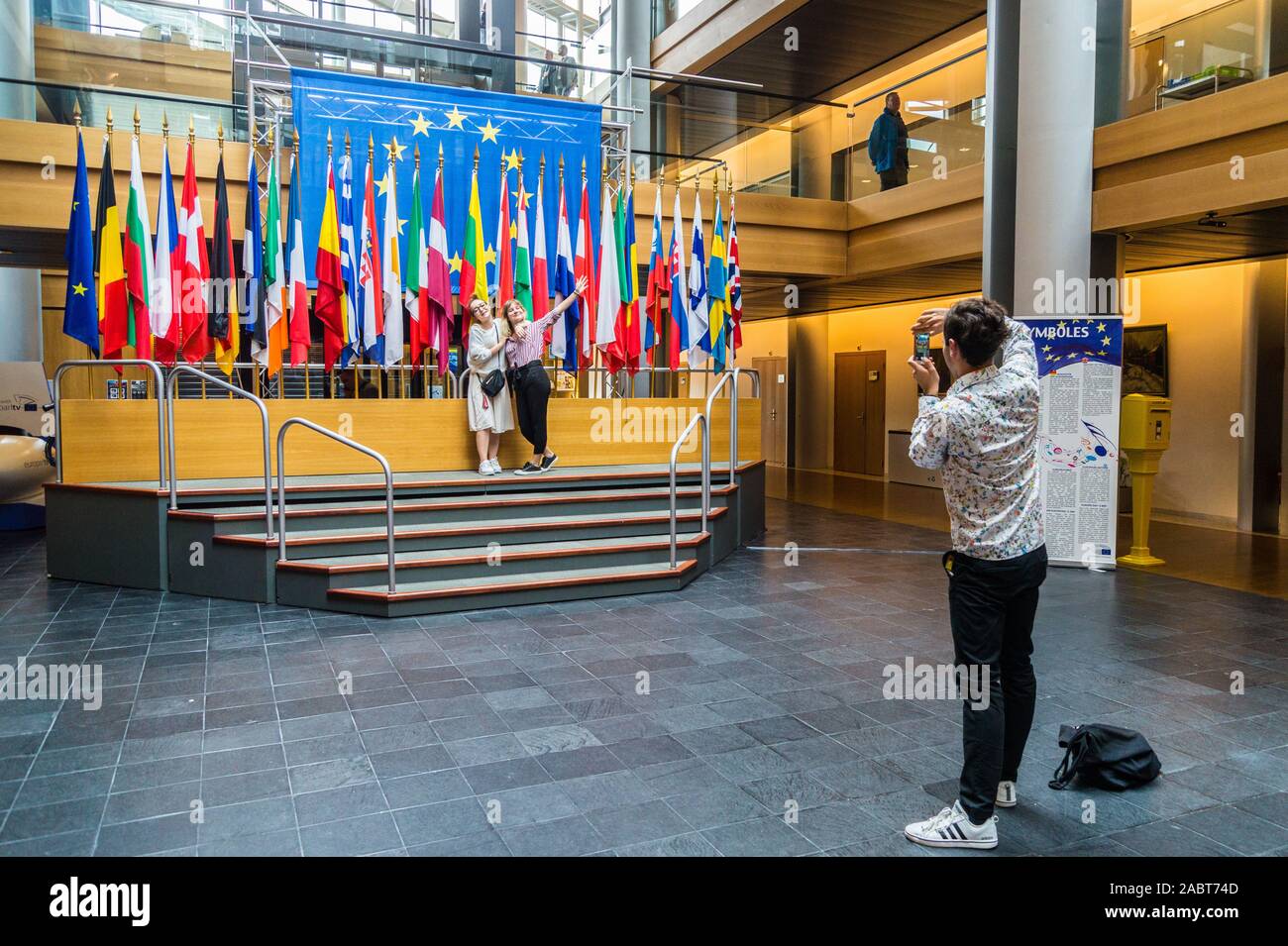 Un groupe de touristes qui pose pour des photos avec les drapeaux des États membres de l'UE, Parlement européen, Strasbourg, Alsace, Grand Est, France Banque D'Images