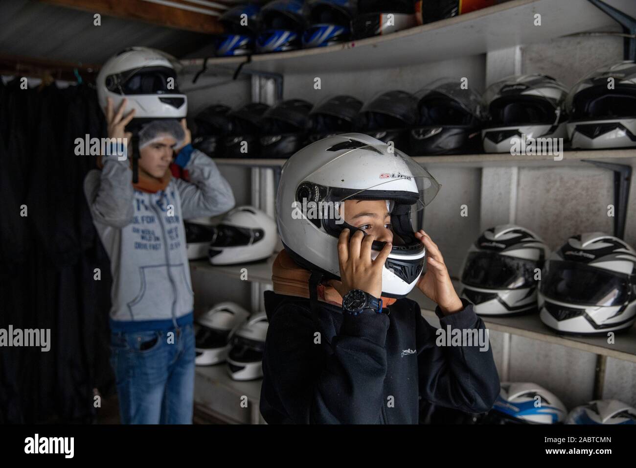 Mettre sur le casque à l'adolescent avant de go-karts. Cabourg, France. Banque D'Images