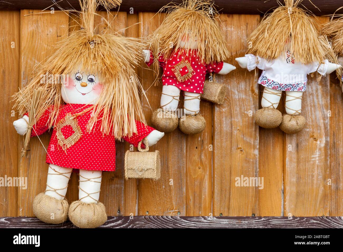 Trois poupées textiles en rouge et blanc T-shirts avec de petites boîtes en bois. Banque D'Images