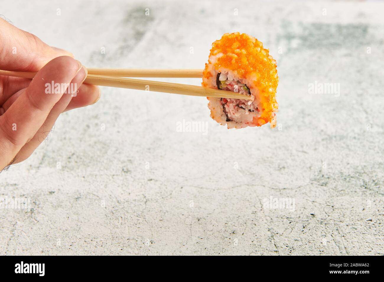 Baguettes contenant des sushis sur fond gris Banque D'Images