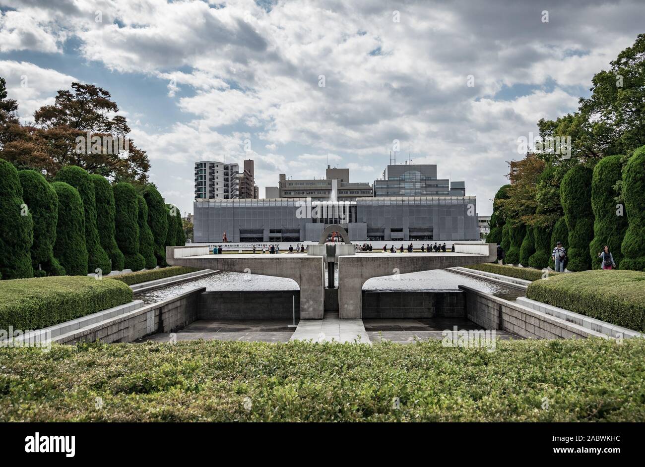 Les touristes flânant dans le Hiroshima Peace Memorial Park à Hiroshima, au Japon avec le Hiroshima Peace Memorial Museum de l'arrière-plan. Banque D'Images