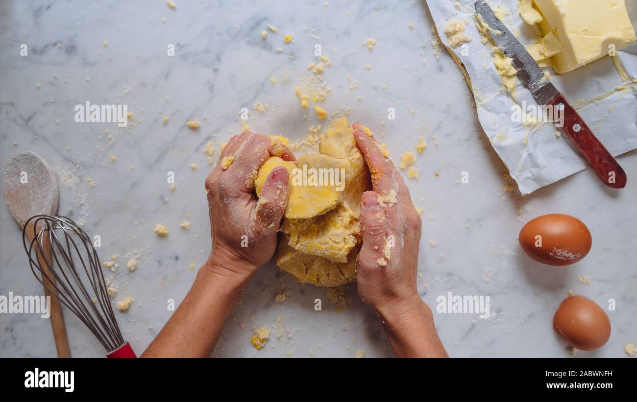 Faire la pâte, caucasian woman mains faire une pâte avec la farine les oeufs et le beurre. pâtisserie maison. fond blanc Banque D'Images