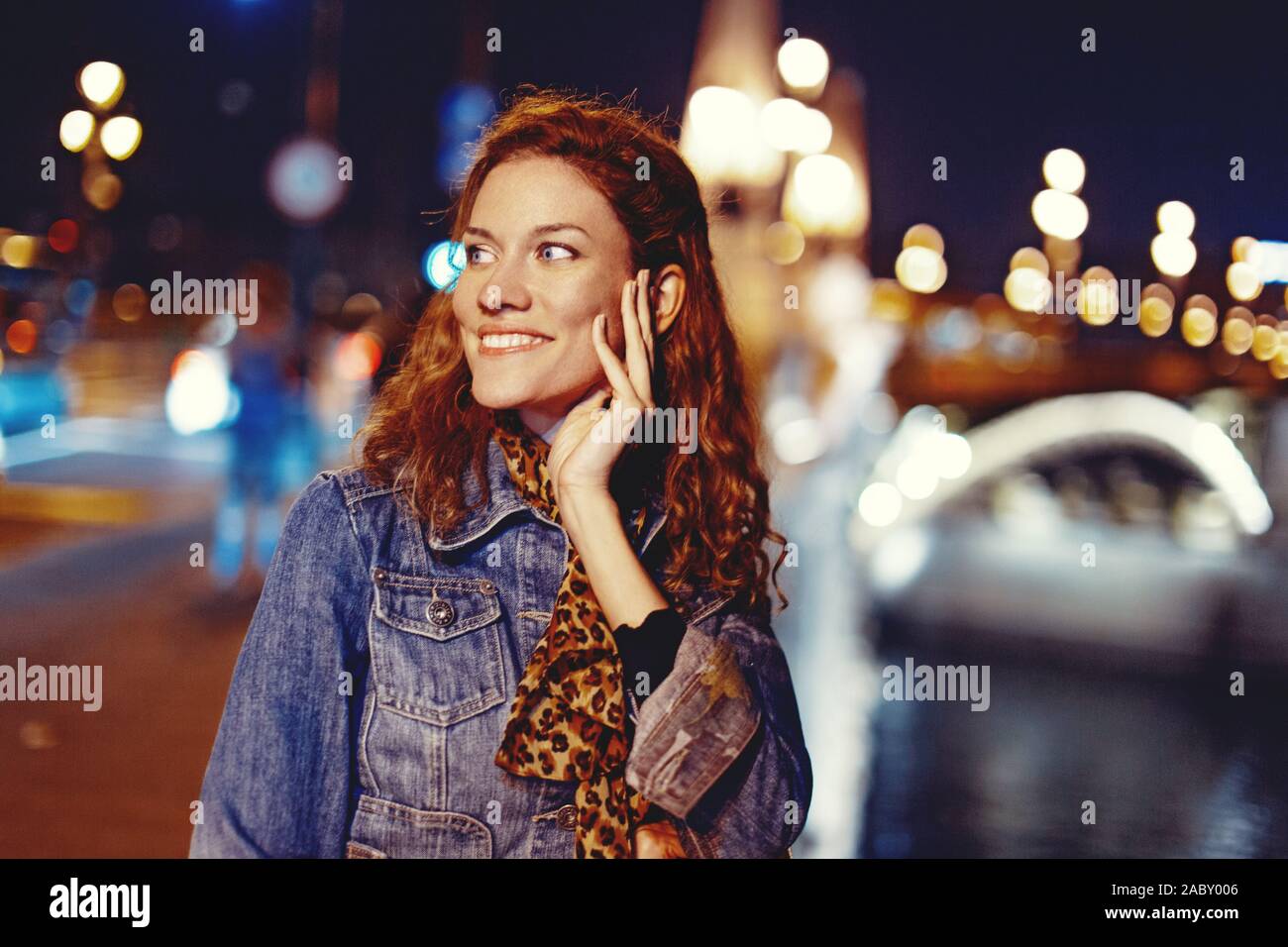 Happy young redhead carefree woman urbaine sur bridge at night, Budapest, Hongrie Banque D'Images