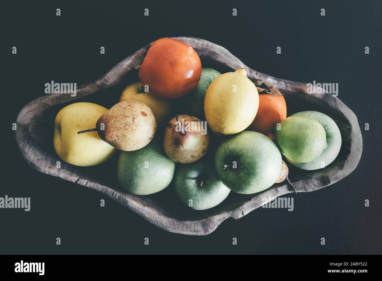 Vue de dessus de fruits biologiques en bol en bois sombre sur fond de table Banque D'Images