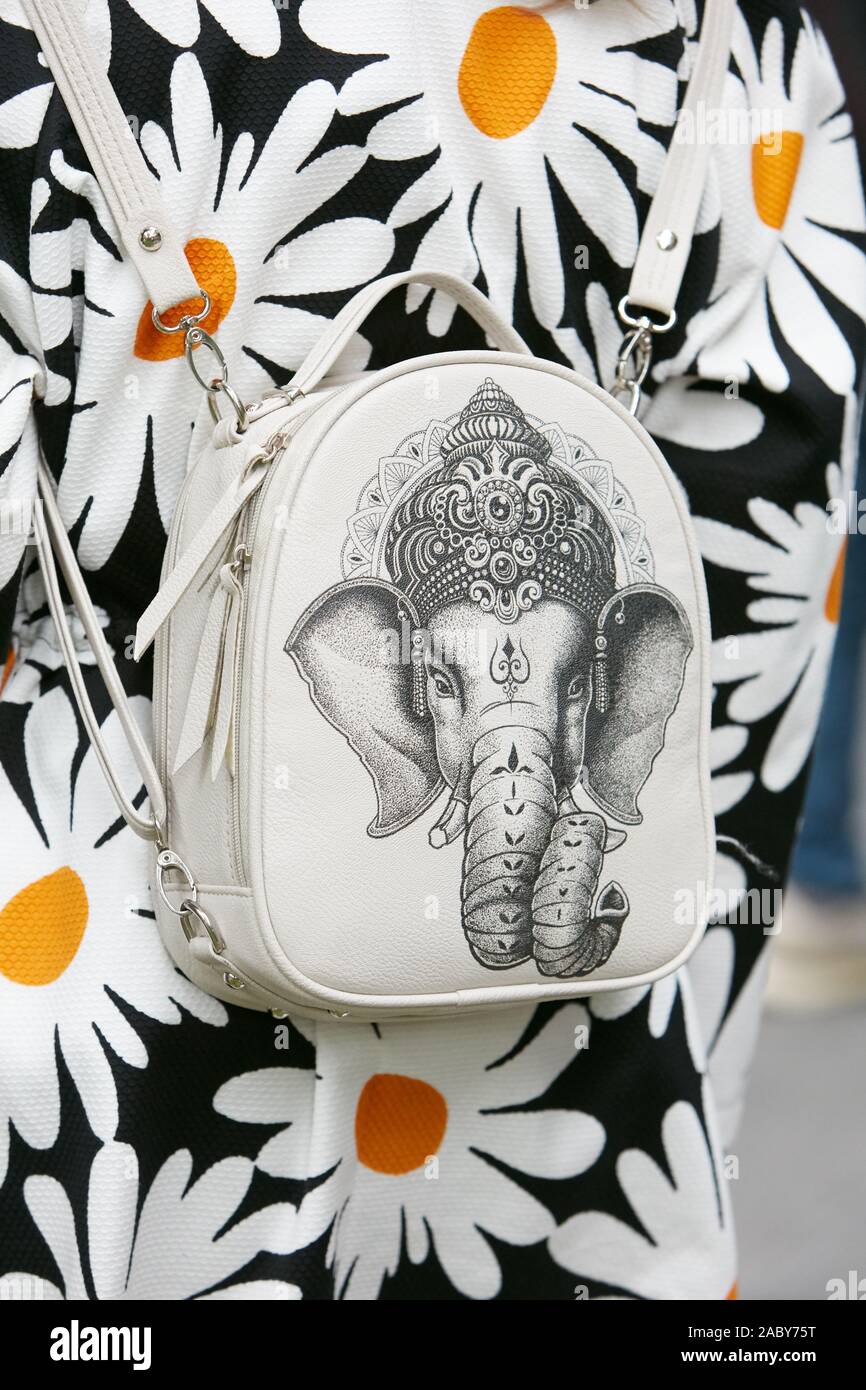 MILAN, ITALIE - 19 septembre 2019 : Femme avec sac à dos d'éléphant blanc avec design et veste avec marguerites avant d'Emporio Armani fashion show, Milan Fa Banque D'Images