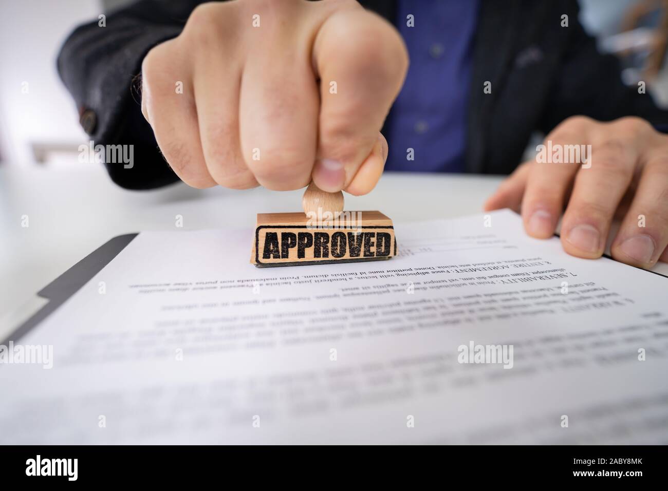 Close-up de personne à l'aide de mains stamper sur le document avec le texte approuvé Banque D'Images