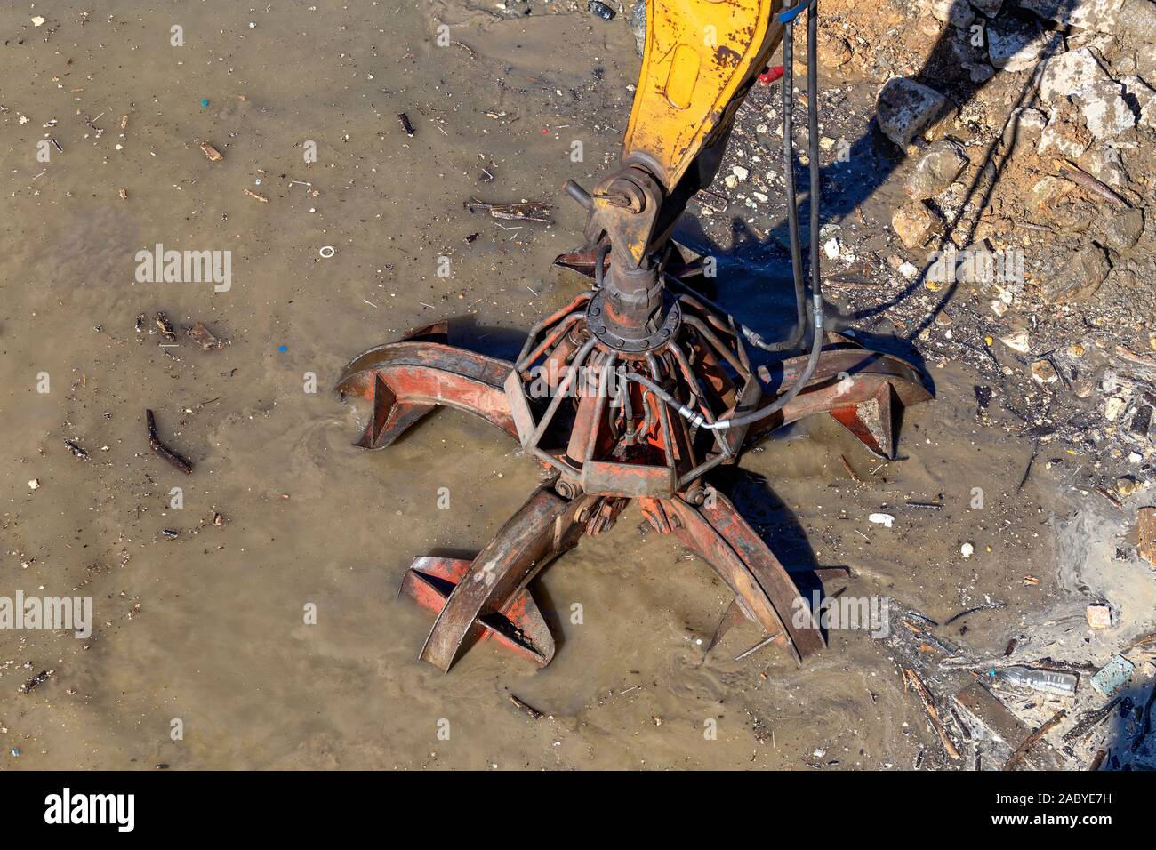 Vanne hydraulique godet crabe cleanin riverbed d'une rivière à partir de la boue et des débris. Banque D'Images