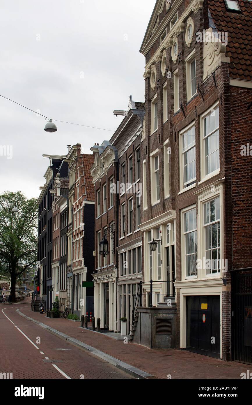 Voir l'historique des bâtiments typiques et traditionnelles, montrant le style architectural Néerlandais à Amsterdam. C'est une journée d'été avec ciel nuageux. Banque D'Images