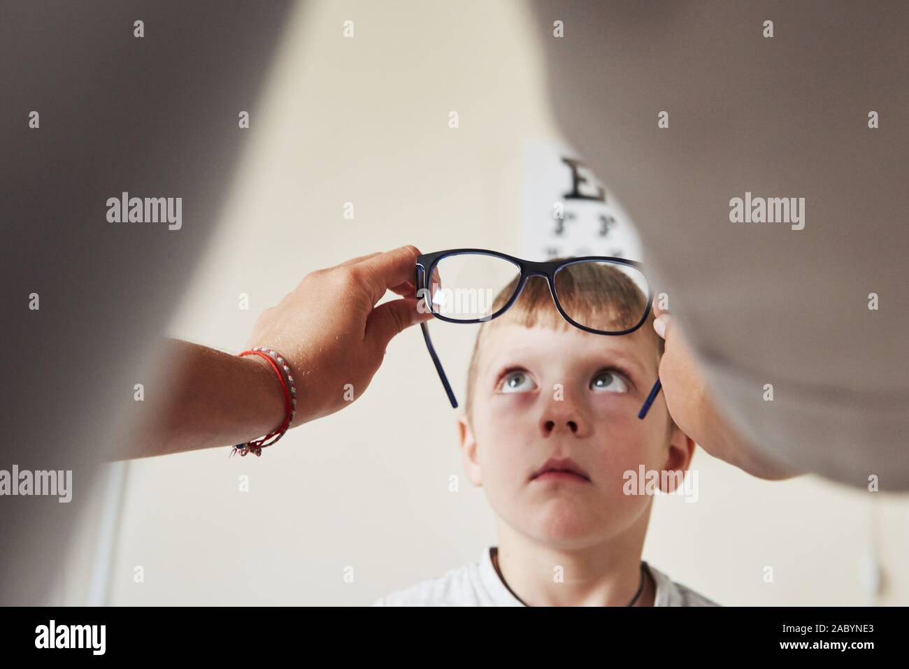 Médecin de donner à l'enfant de nouvelles lunettes noires pour sa vision Banque D'Images