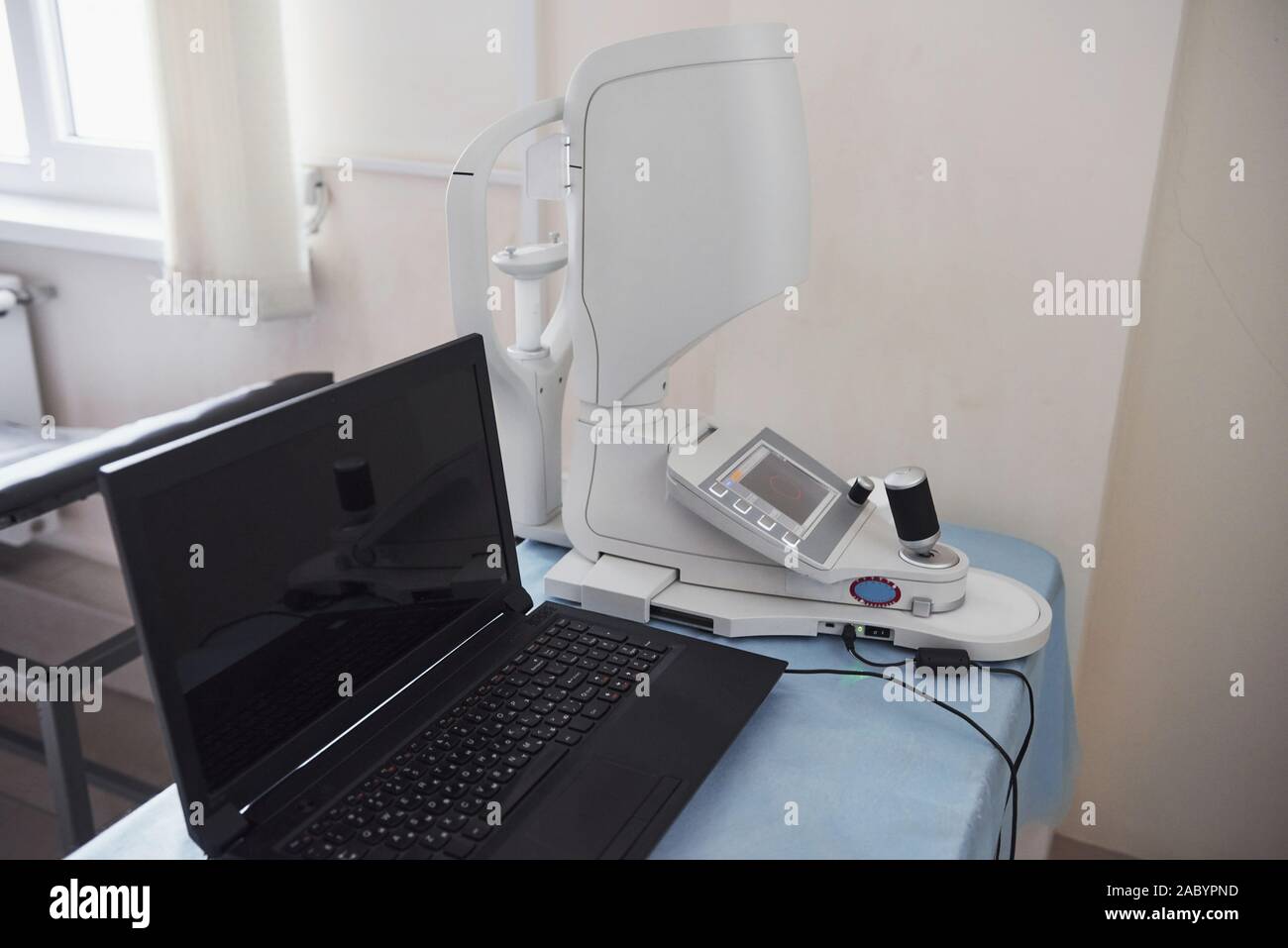 Lieu de travail du médecin. Ordinateur portable et de l'équipement ophtalmique sur la table Banque D'Images