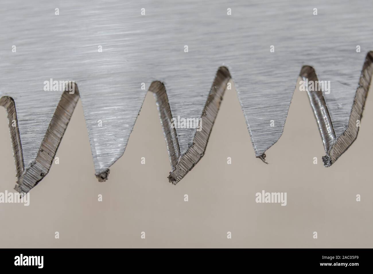 Macro close-up shot des dents d'une lame courte folding garden scie d'élagage. Métaphore très forte, à la pointe, des dents pointues en métal. Banque D'Images