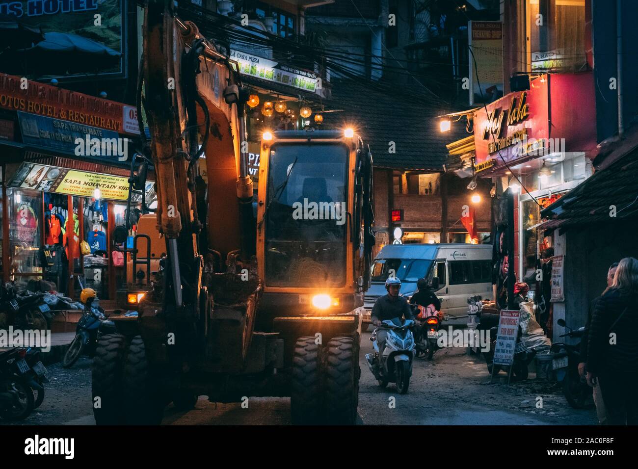 Sapa, Vietnam - 8 octobre 2019 : Diggers voyage à travers les rues étroites de Sapa pendant la nuit car ils élargir et développer la ville touristique Banque D'Images