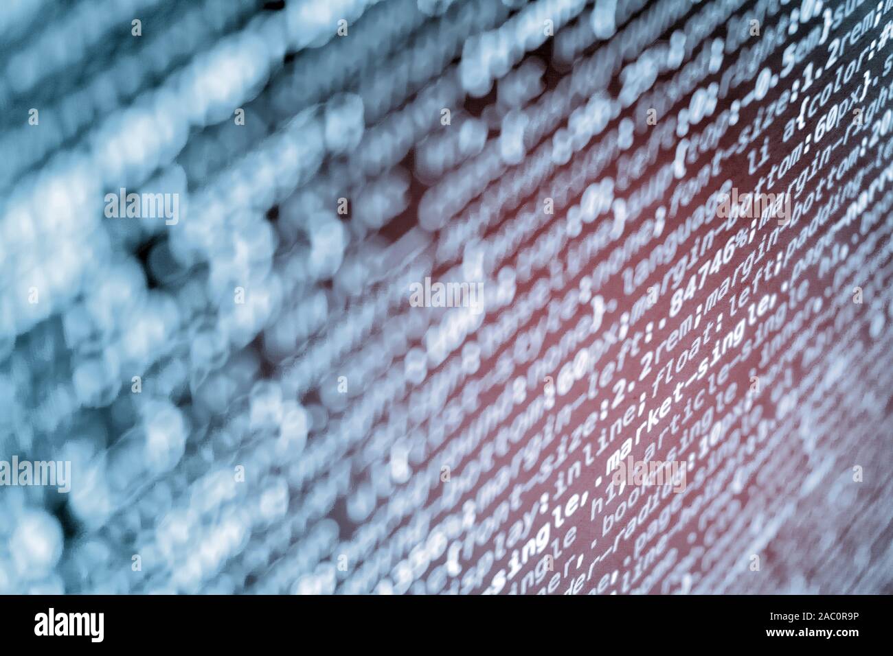 Le code de programmation CSS compressé à l'écran dans des tons bleus et fuite de lumière rouge Banque D'Images