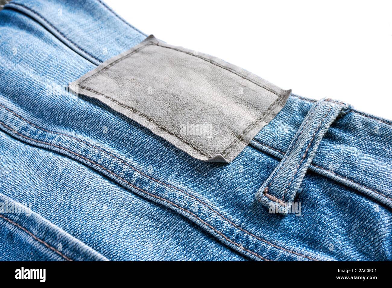 Close-up de vêtements de cuir blanc étiquette sur un jean bleu avec boucle  de ceinture. Isolé sur haut pour copier l'espace Photo Stock - Alamy