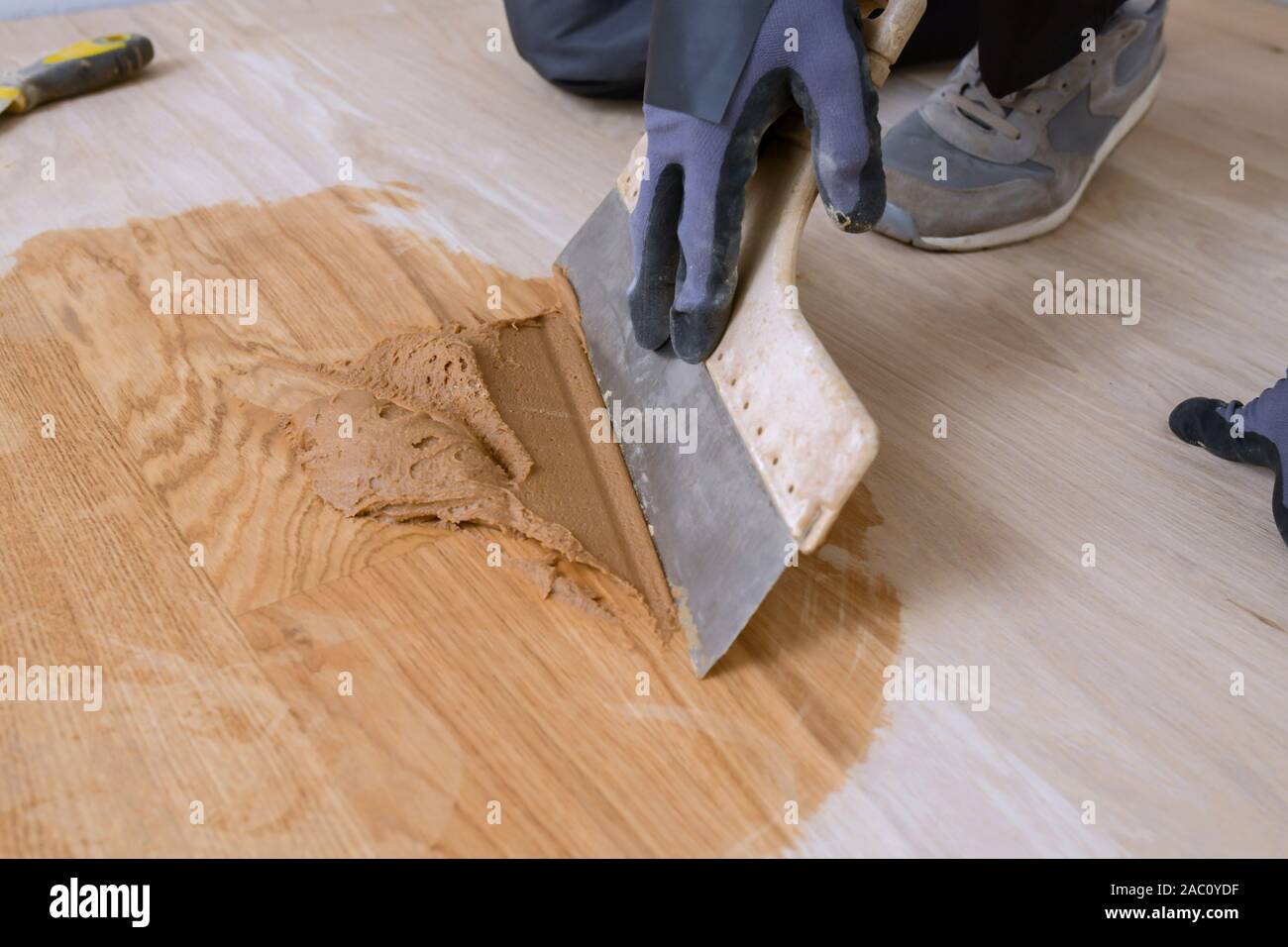 Master plancher à l'aide d'une spatule dans la main. Préparation du coulis de parquet. La retenue de mélange, de vernis et d'un petit mélange de bois. Vernissage-pré Banque D'Images