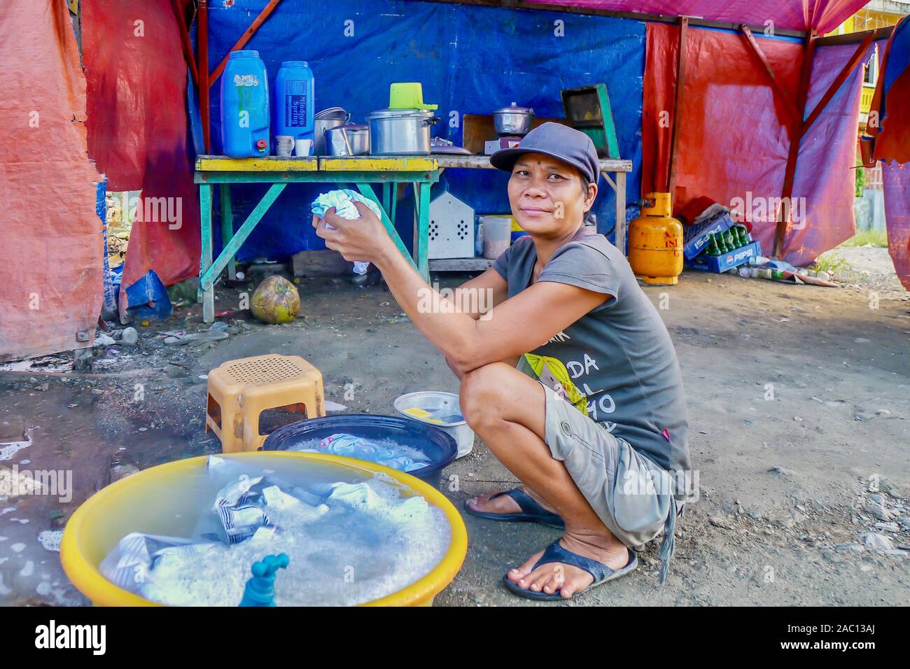 Une femme vivant sous des bâches en plastique, avec un sol de la saleté et des nécessités de base seulement, parce qu'elle ne peut pas se permettre une vraie maison. Banque D'Images