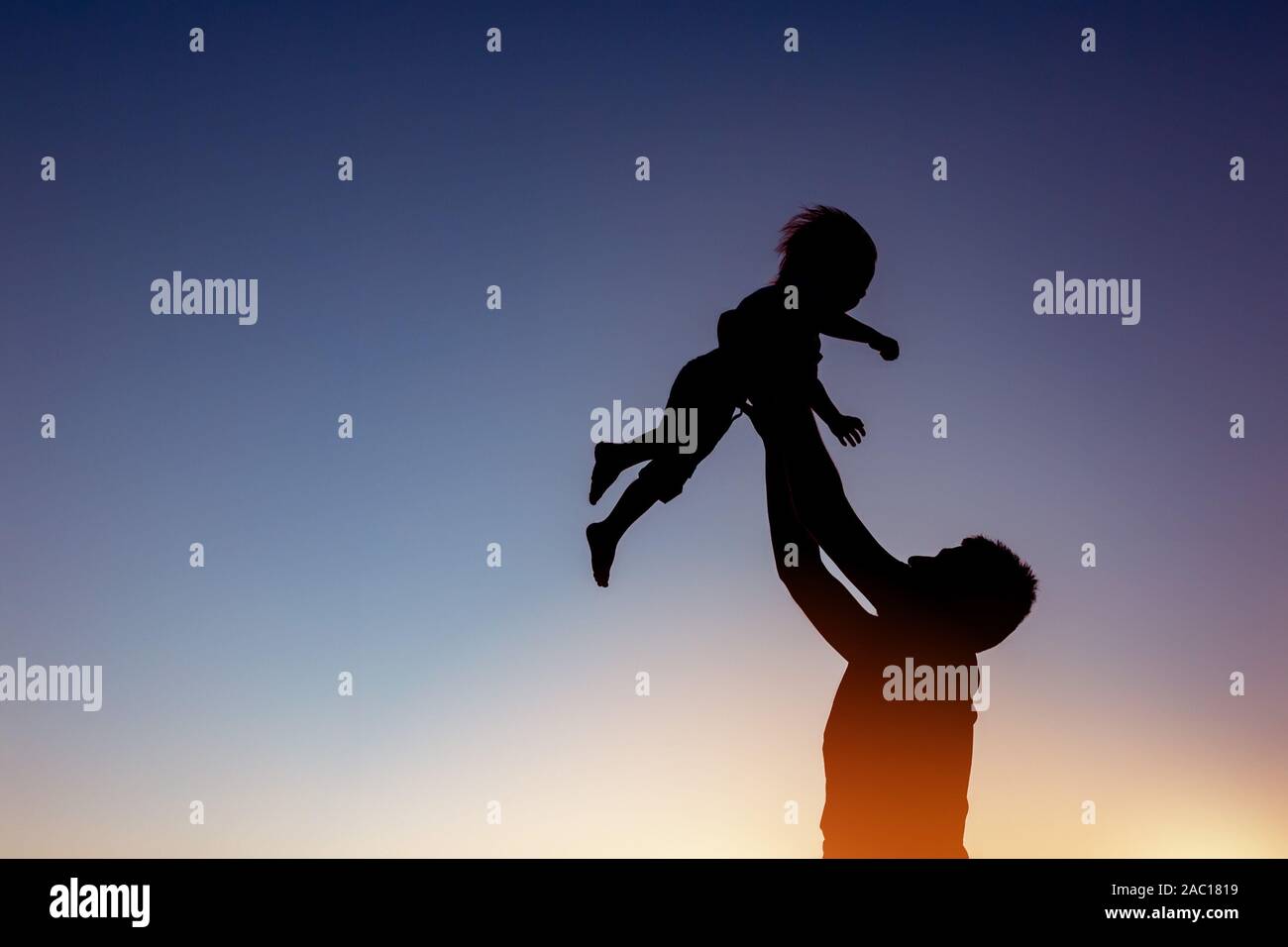 Père et fils concept care avec deux silhouettes jouant contre sunset sky Banque D'Images