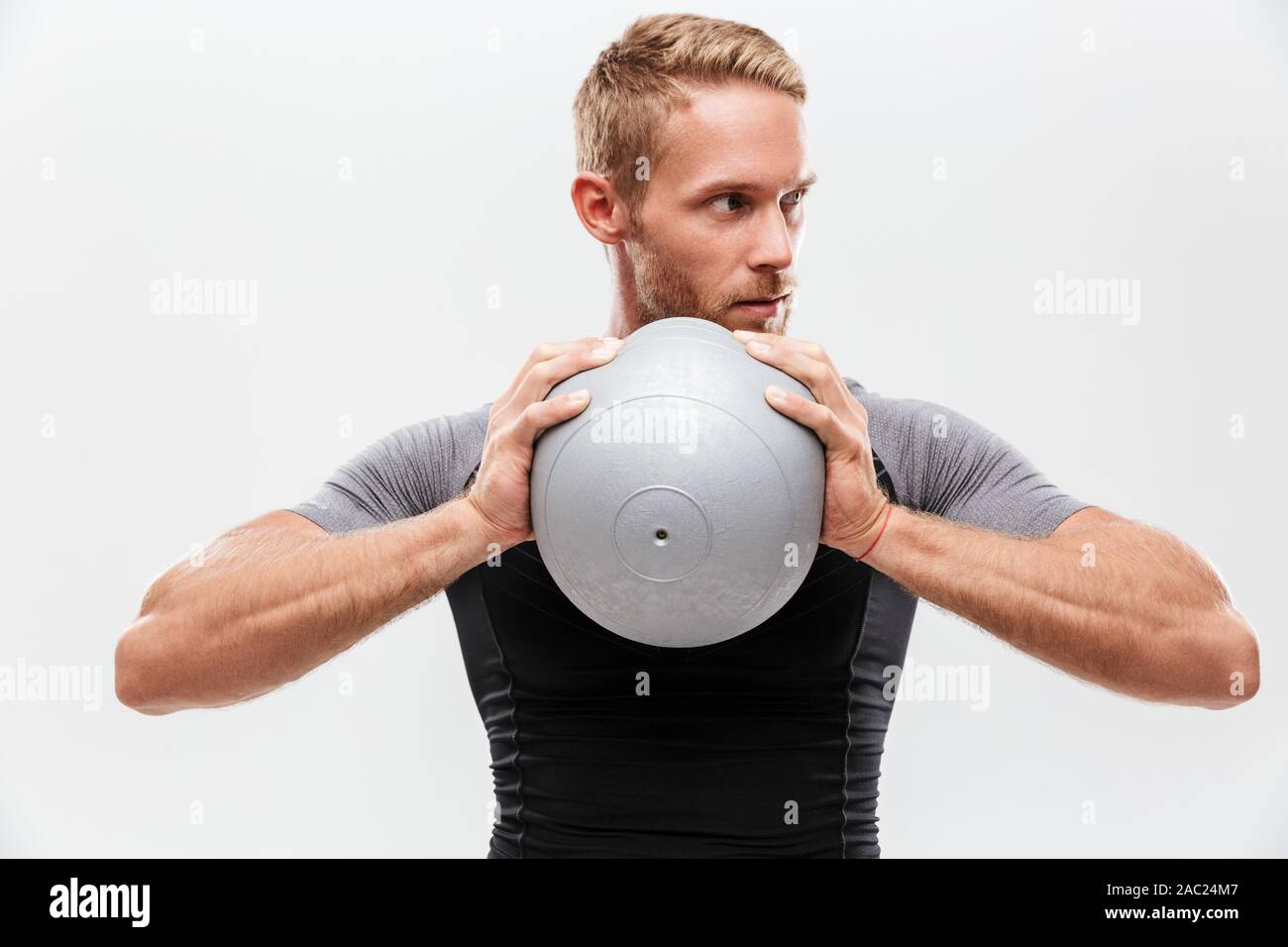 Certain beau jeune sportif fit faire les exercices avec fitness ball isolated over white background Banque D'Images