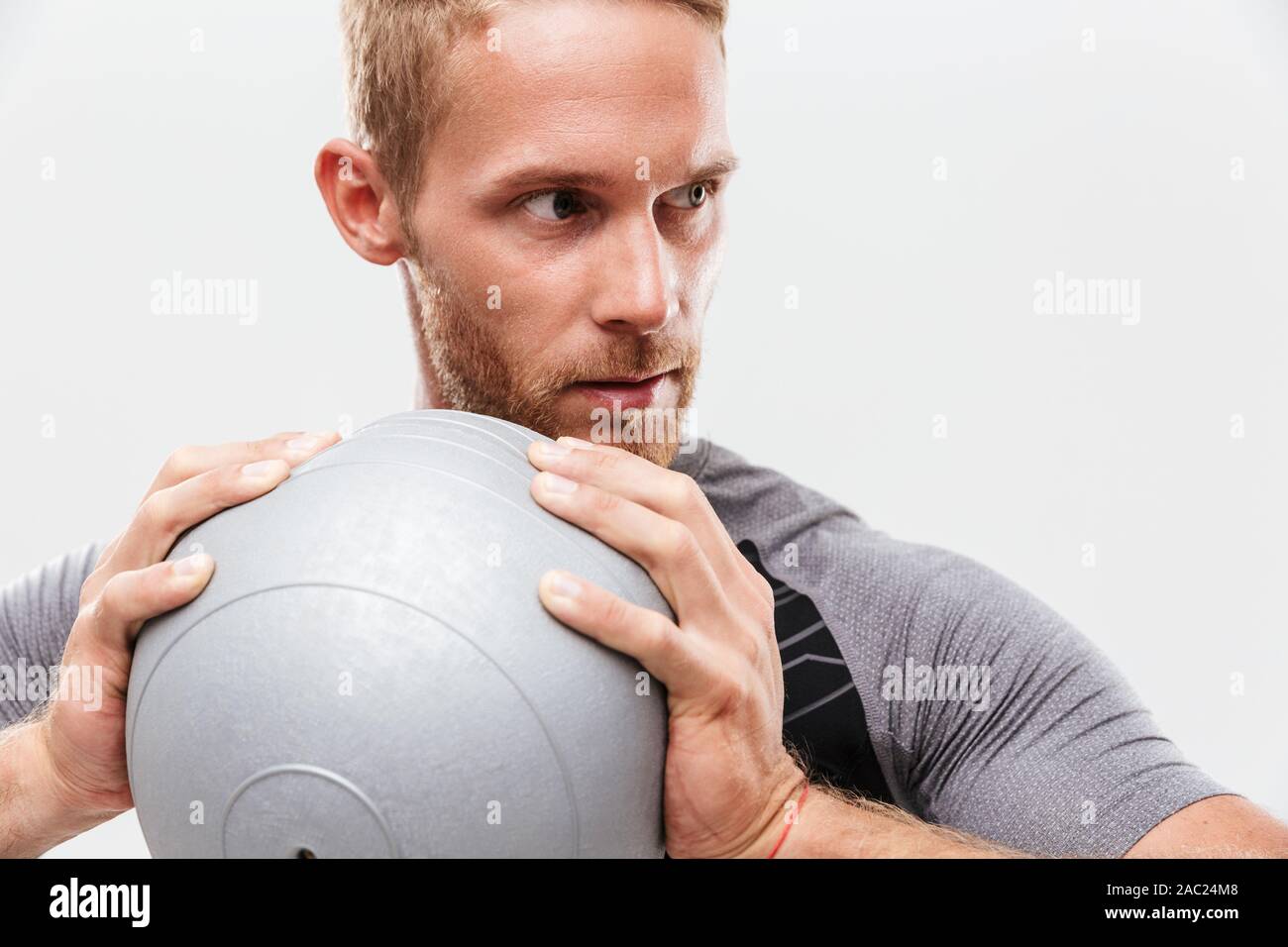 Certain beau jeune sportif fit faire les exercices avec fitness ball isolated over white background Banque D'Images