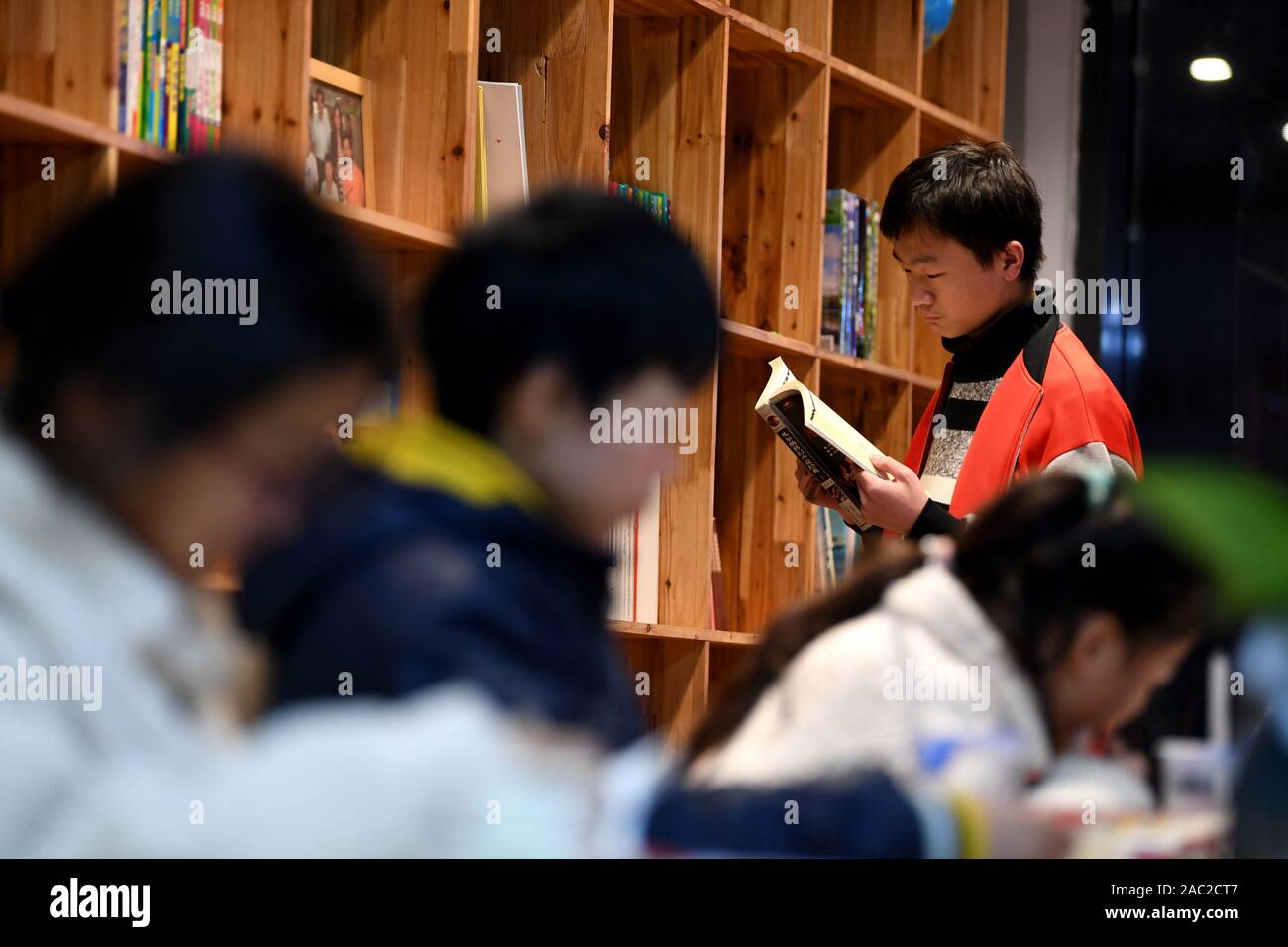 (191130) -- SHANGHAI, le 30 novembre 2019 (Xinhua) -- un Junjun, orphelins touchés par le VIH/SIDA, lit un livre dans la ville de Fuyang, province de Anhui, Chine orientale, le 25 novembre 2019. C'est difficile de se connecter 18 ans Junjun avec un orphelins touchés par le VIH/SIDA. Étudier dans une école secondaire à Fuyang, le malheureux garçon confiant mais ressemble à ses pairs. Naissance d'un bébé infecté par le VIH en raison de la transmission mère-enfant en 2001, Junjun devenu orphelin en 2004, après que ses parents sont morts du VIH/SIDA. Adopté par l'Association de Fuyang orphelin du SIDA Salut, Junjun a été en mesure de recevoir la même éducation que les enfants ordinaires et de profiter d'un Banque D'Images