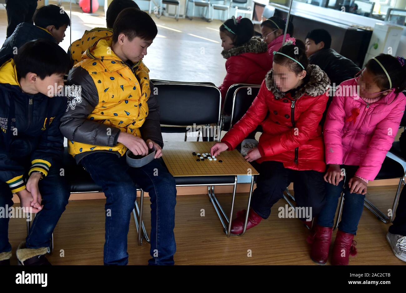 (191130) -- SHANGHAI, le 30 novembre 2019 (Xinhua) -- Junjun (2L) et d'autres enfants rendus orphelins par le VIH/SIDA jouent aux échecs dans la ville de Fuyang, province de Anhui, Chine orientale, le 1er décembre 2016. C'est difficile de se connecter 18 ans Junjun avec un orphelins touchés par le VIH/SIDA. Étudier dans une école secondaire à Fuyang, le malheureux garçon confiant mais ressemble à ses pairs. Naissance d'un bébé infecté par le VIH en raison de la transmission mère-enfant en 2001, Junjun devenu orphelin en 2004, après que ses parents sont morts du VIH/SIDA. Adopté par l'Association de Fuyang orphelin du SIDA Salut, Junjun a été en mesure de recevoir la même éducation que l'enfant ordinaire Banque D'Images