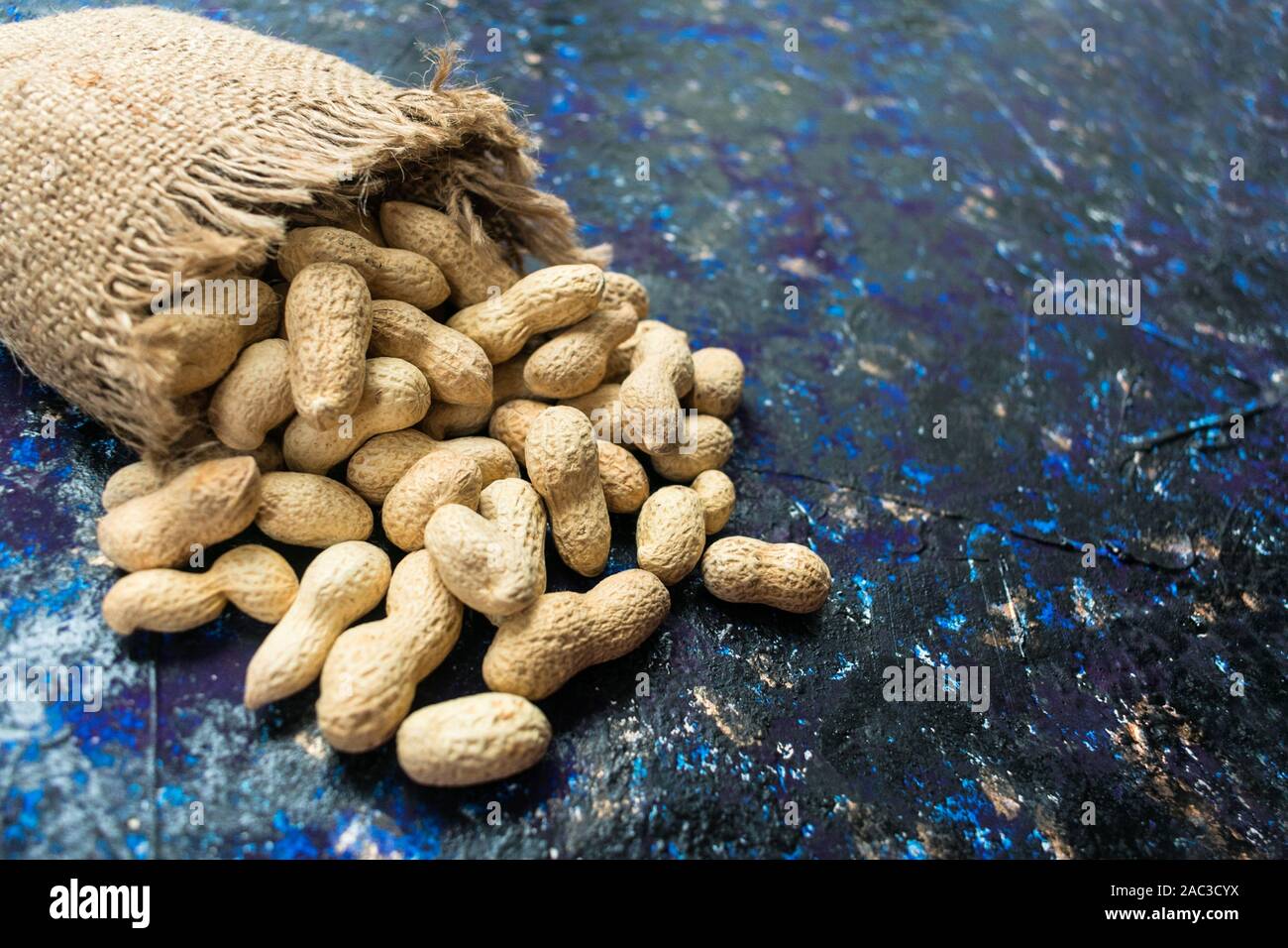 Arachides non pelées sur fond bleu. Close-up. Les haricots d'arachide. Banque D'Images