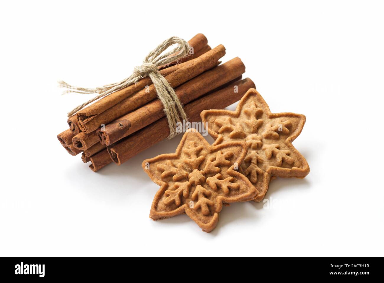 Des bâtons de cannelle avec les biscuits de Noël sur blanc backgroun Banque D'Images