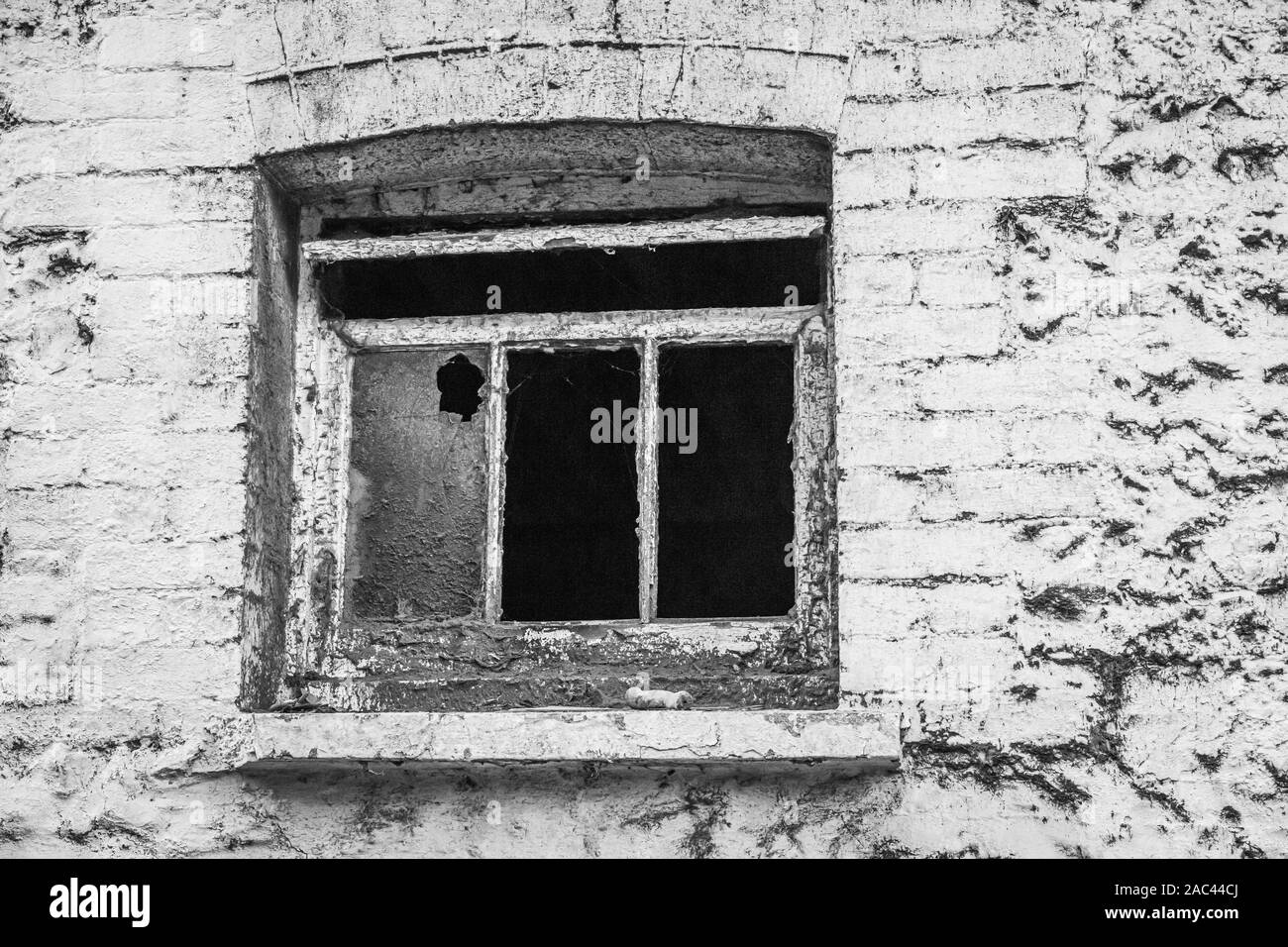 Grange en brique à l'abandon avec une fenêtre brisée Banque D'Images