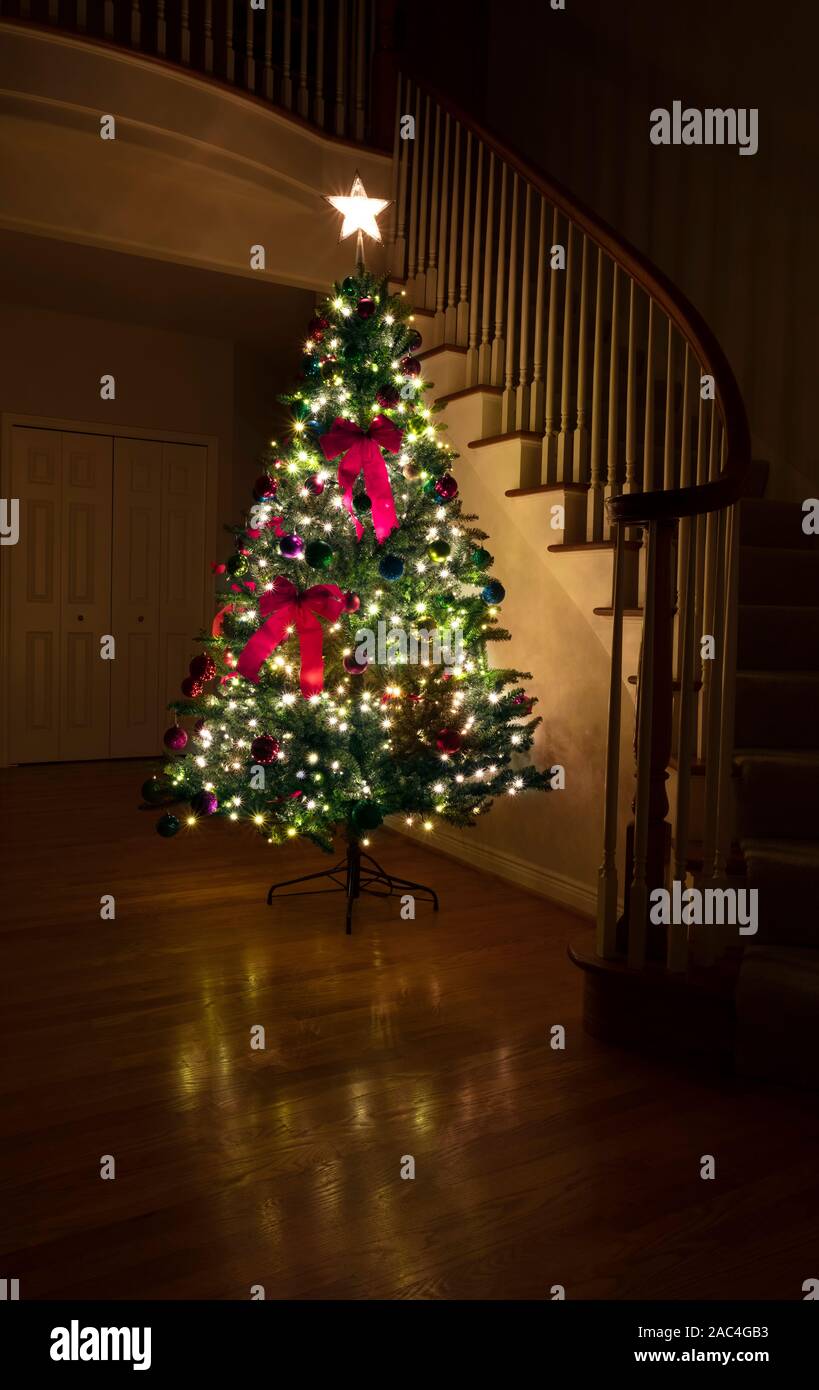 Arbre de Noël décoré allumé dans la maison pendant la nuit Banque D'Images