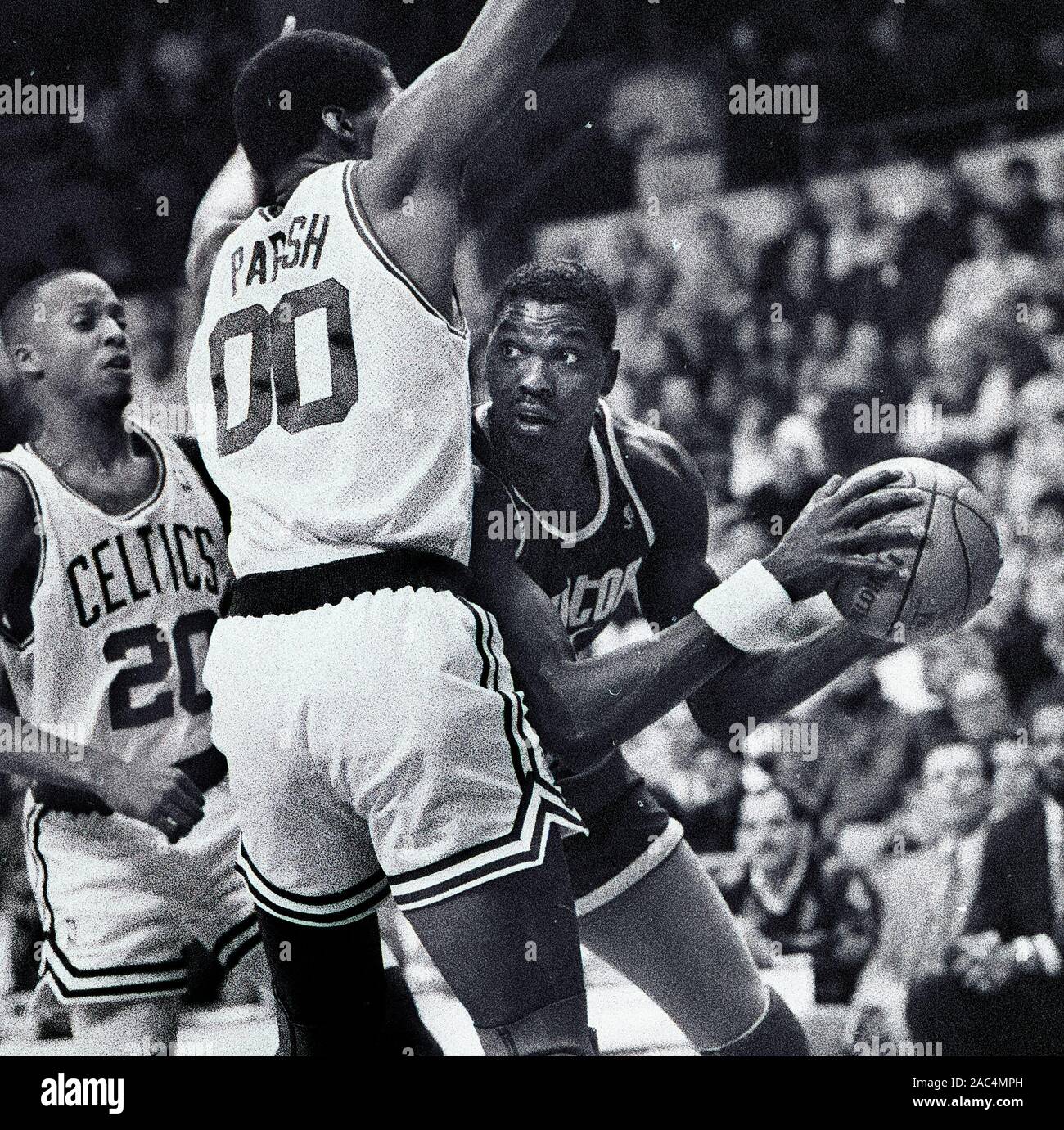 Les Houston Rockets Hakeem Olajuwon a l'air de passer la balle avec Boston Celtics # 00 Robert Parish défendre et # 20 Eric Shaw (à gauche) au cours de l'action de jeu de basket-ball au Garden de Boston Boston MA USA 1988photo de Bill belknap Banque D'Images