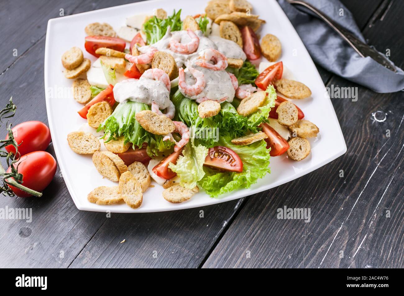 Close-up appétissante salade avec crevettes, laitue, fromage, avocat et craquelins sur une plaque blanche. Recettes de fruits de mer délicieux et sains. Peu de calories Banque D'Images