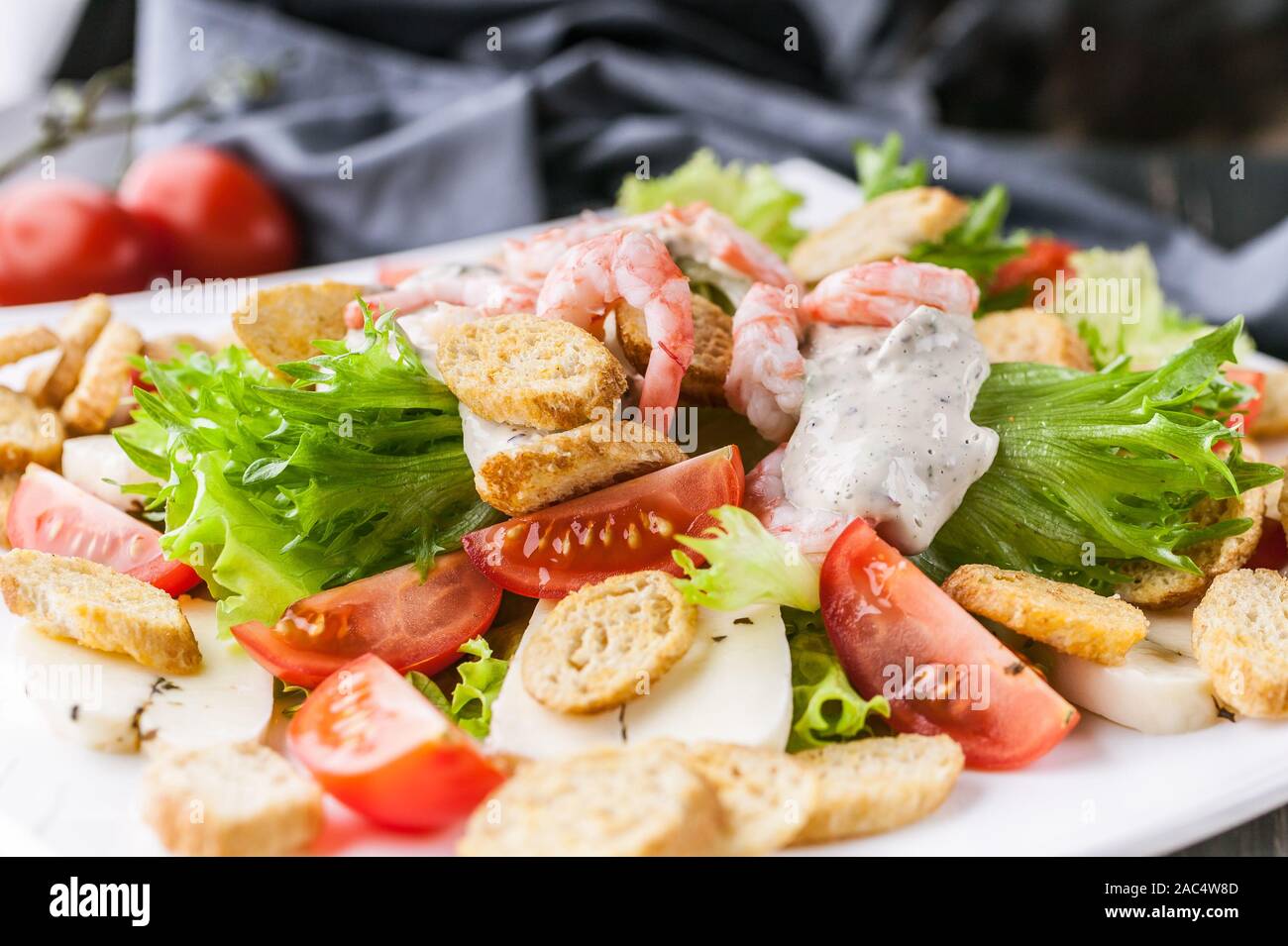 Close-up appétissante salade avec crevettes, laitue, fromage, avocat et craquelins sur une plaque blanche. Recettes de fruits de mer délicieux et sains. Peu de calories Banque D'Images