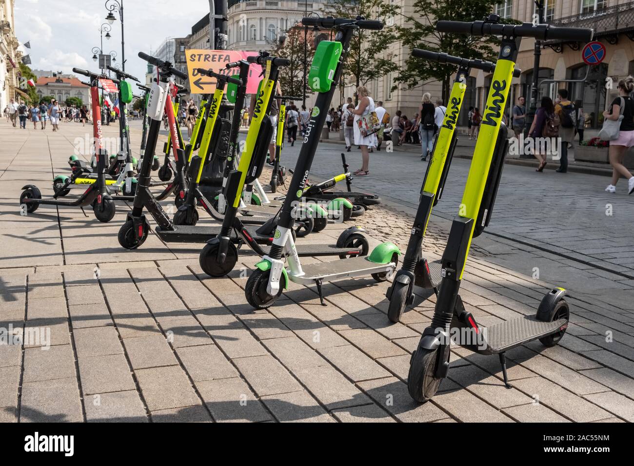 Beaucoup de scooters électriques, escooter ou e-scooter de la ruche d'entreprise partage ride sur un trottoir de gauche à Varsovie, Pologne Banque D'Images