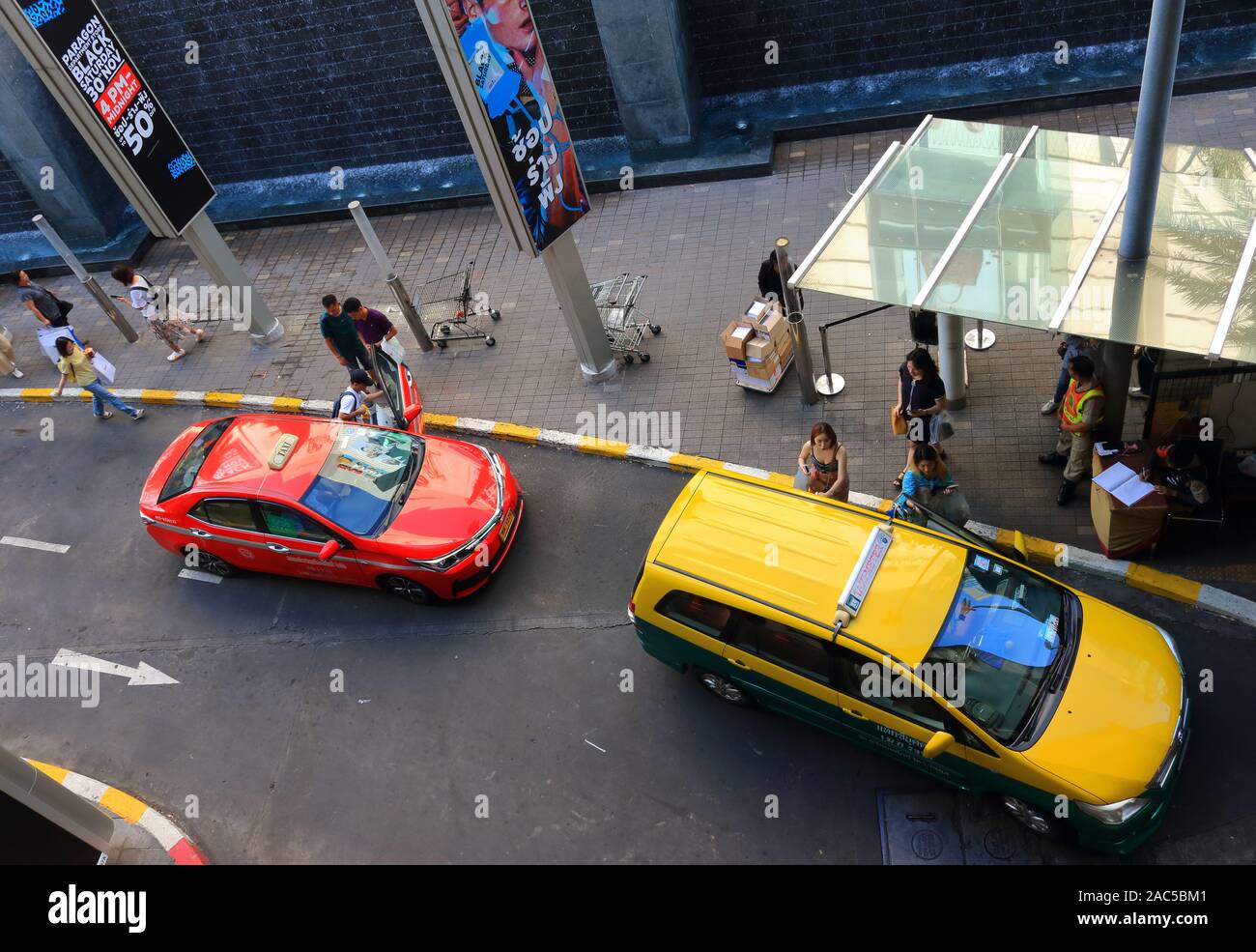 Bangkok, Thaïlande - 29 novembre 2019 : les touristes ne sont pas axées sur les voitures de taxi à bordure jaune blanc zone de chargement en face de Paragon shopping mall Banque D'Images
