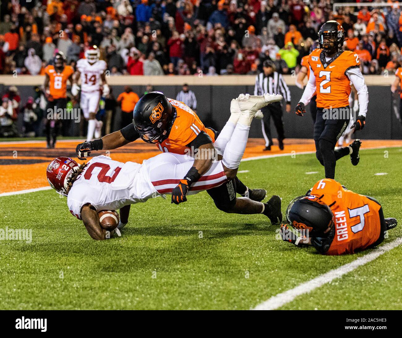 Stillwater, Oklahoma, USA. 30Th Nov, 2019. Oklahoma Sooners wide receiver michelf Lamb (2) plongée sous-marine de l'avant comme Oklahoma State Cowboys A.J. évoluait Vert (4) et le secondeur Amen Ogbongbemiga (11) Faire de l'attaquer durant le jeu Samedi, 30 novembre 2019 à Boone Pickens Stadium à Stillwater, Oklahoma. Credit : Nicholas Rutledge/ZUMA/Alamy Fil Live News Banque D'Images