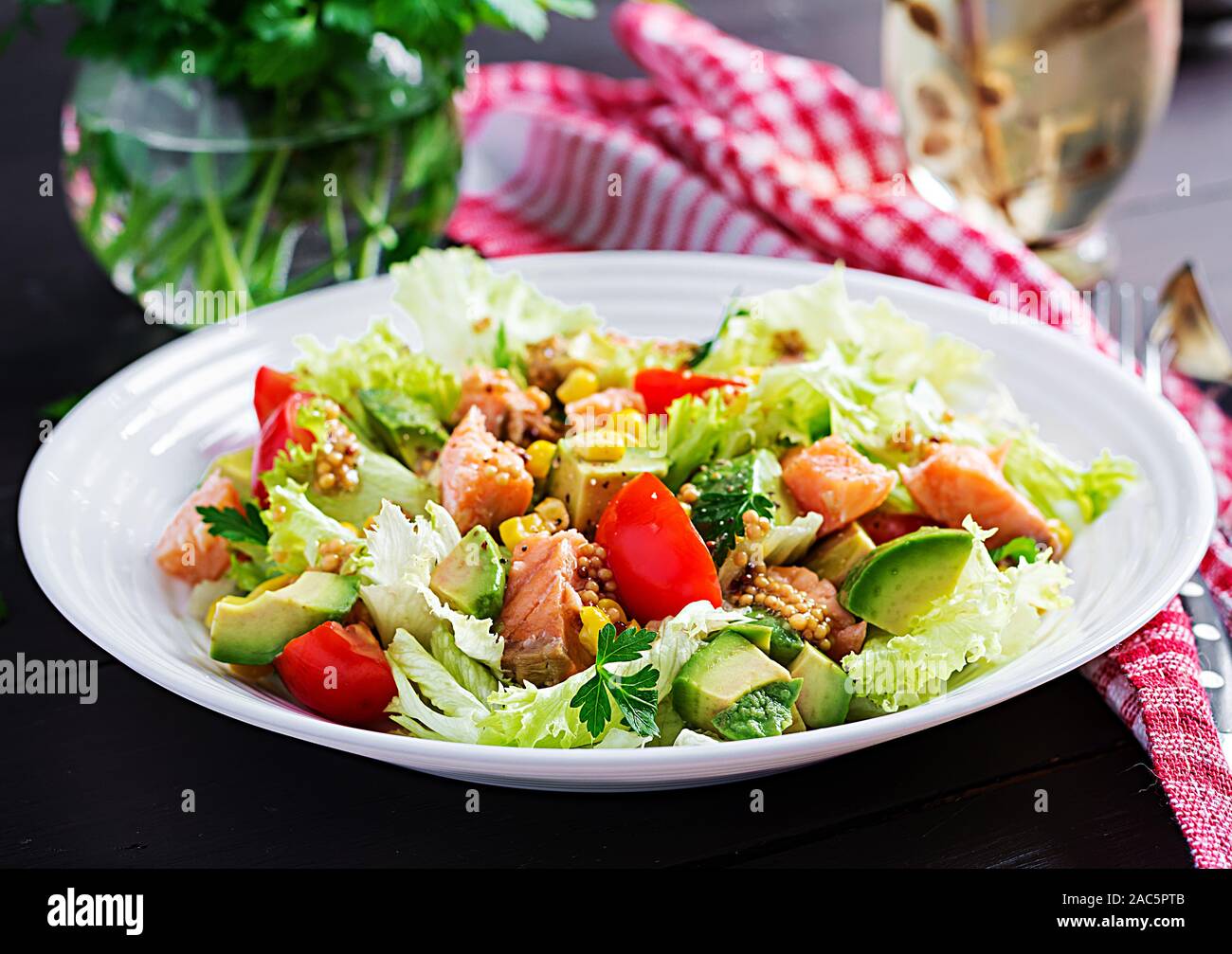 Salade avec du saumon grillé, laitue, Avocat, tomates et le maïs sur une boule blanche. Paleo diet. Banque D'Images