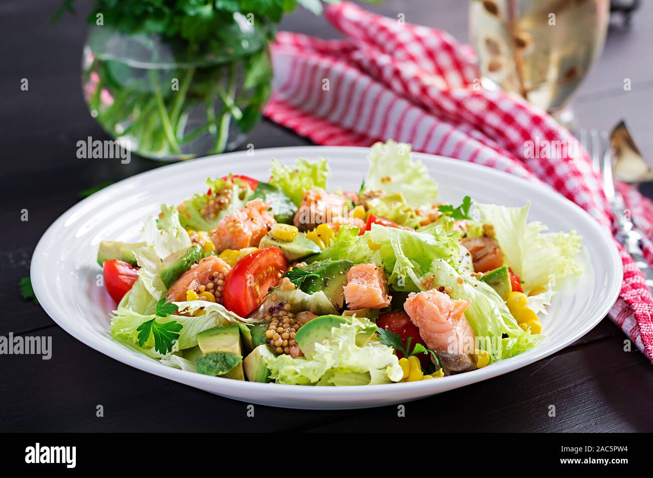 Salade avec du saumon grillé, laitue, Avocat, tomates et le maïs sur une boule blanche. Paleo diet. Banque D'Images