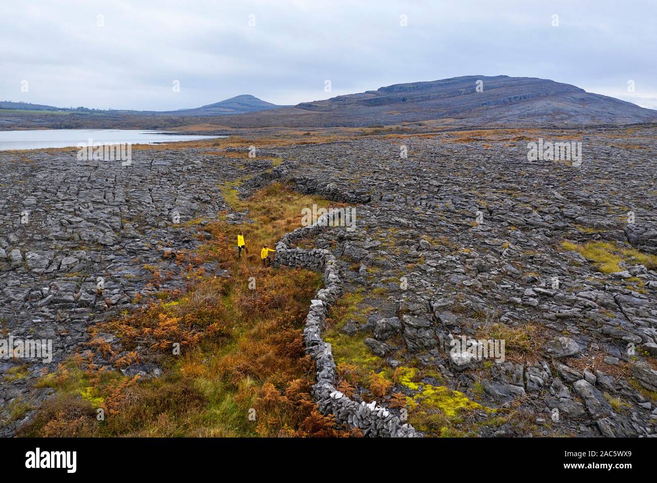 Vue aérienne du paysage karstique, un lac et des murs en pierre, prises par drone. Le Burren, comté de Clare. L'Irlande Banque D'Images