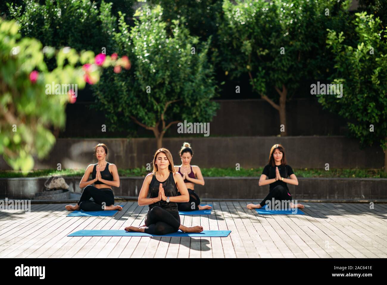 Vue sur les femmes face à la relaxation le yoga dans le jardin. Banque D'Images