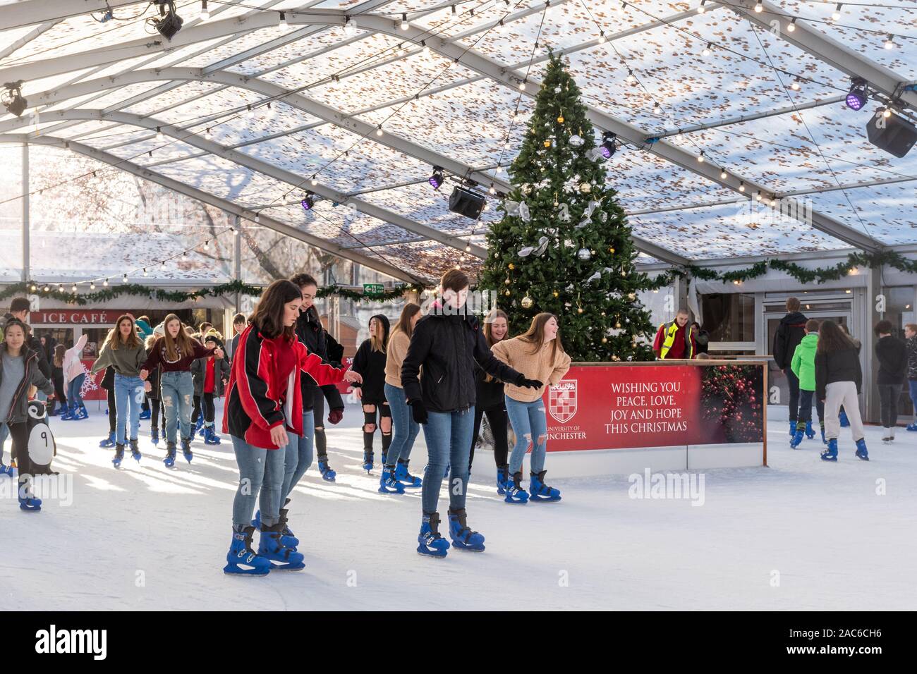 Les gens le patinage sur glace à la patinoire en centre-ville de Winchester au cours de la saison de Noël, Hampshire, Royaume-Uni Banque D'Images