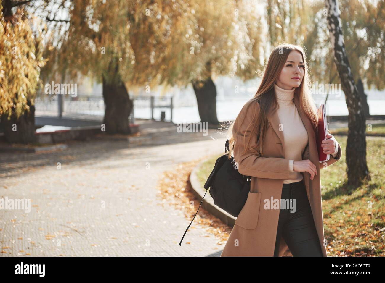 Portrait de jeune fille blonde qu'avoir reste tout en marchant dans le parc en automne Banque D'Images