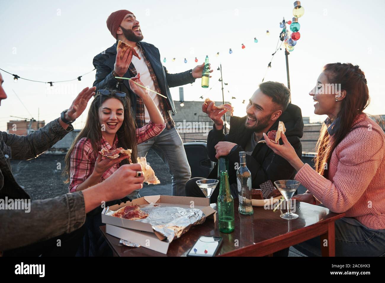 Voix de ce type qui s'est aimé par tout le monde. Manger une pizza à la soirée sur le toit. Bon week-end avec des amis ont une délicieuse nourriture et alcool Banque D'Images