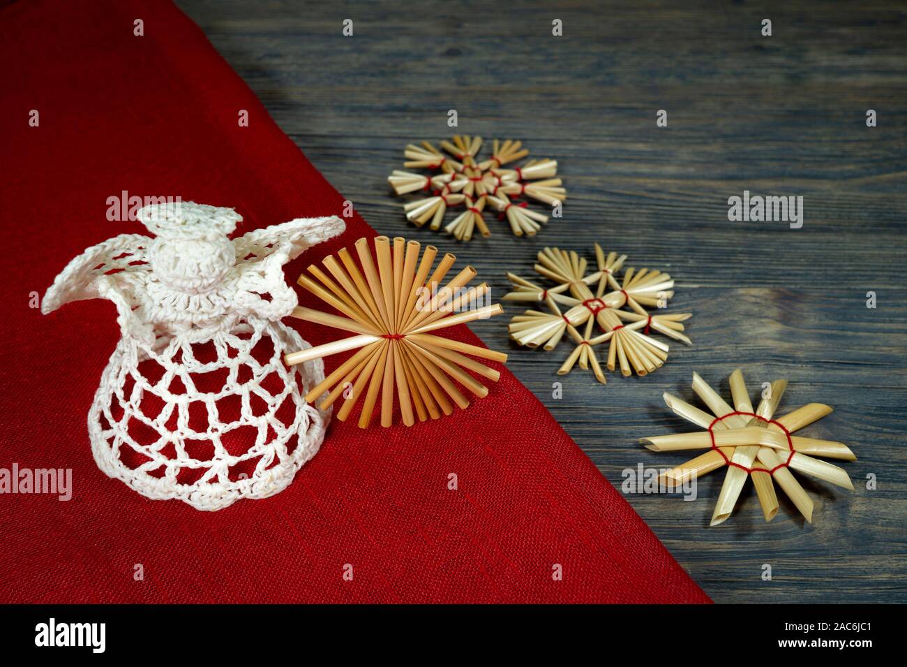 Noël encore la vie rustique avec des ornements de paille, un ange au crochet, tissu rouge correspondant sur un fond de bois, eco friendly pour Noël Banque D'Images