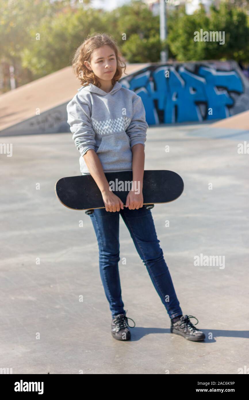 Adolescente de fille avec une planche à roulettes. À la mode belle planche  en jean et un sweat sur la rampe Photo Stock - Alamy