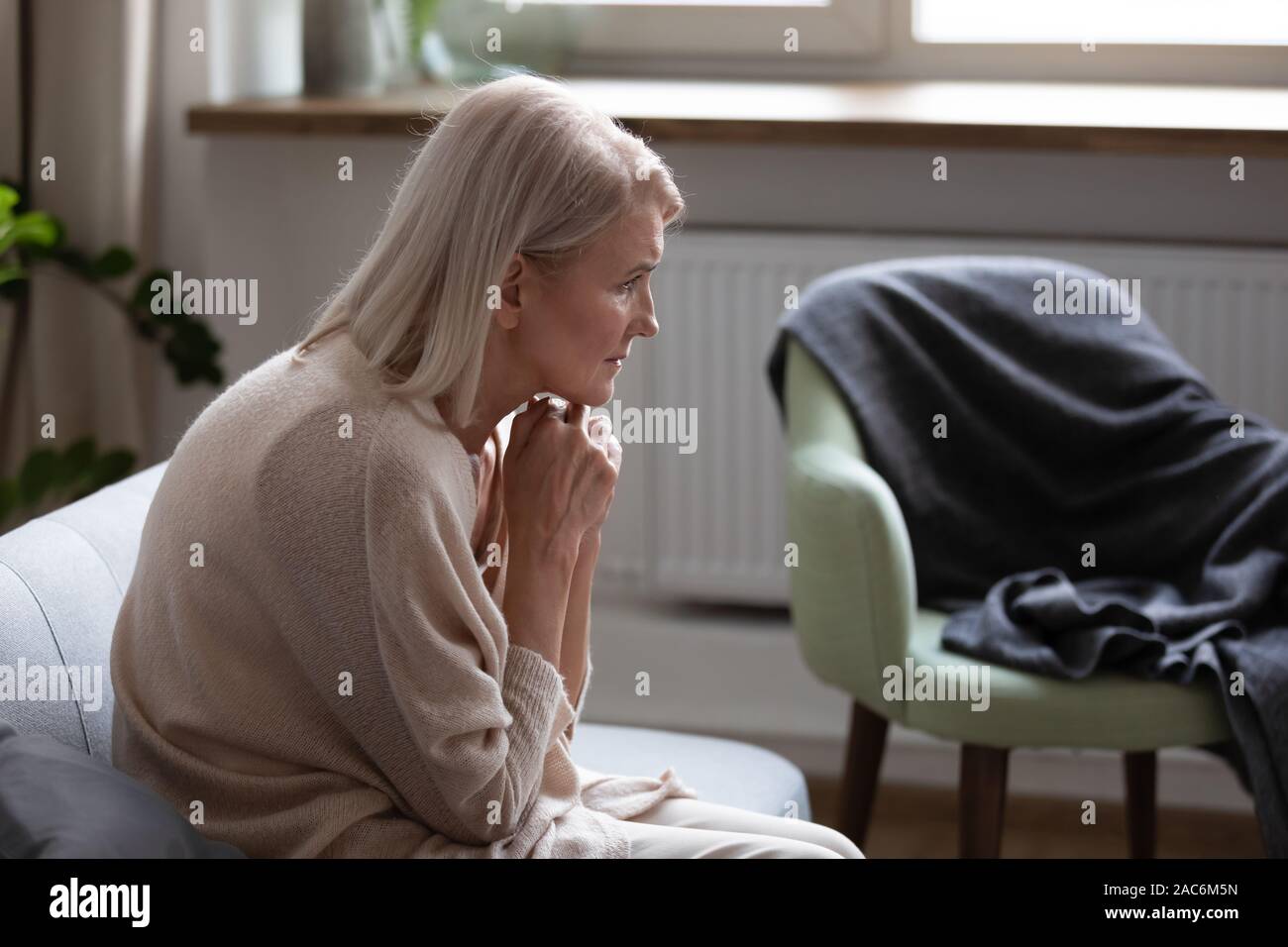 Femme courbée de la pensée d'estomac assis sur table Banque D'Images