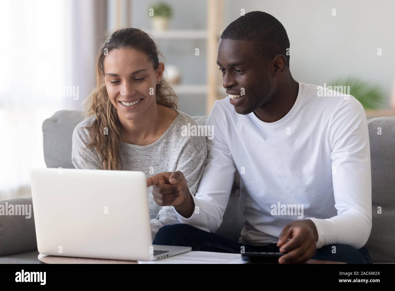 Happy mixed race family conjoint effectuant des calculs budgétaires. Banque D'Images