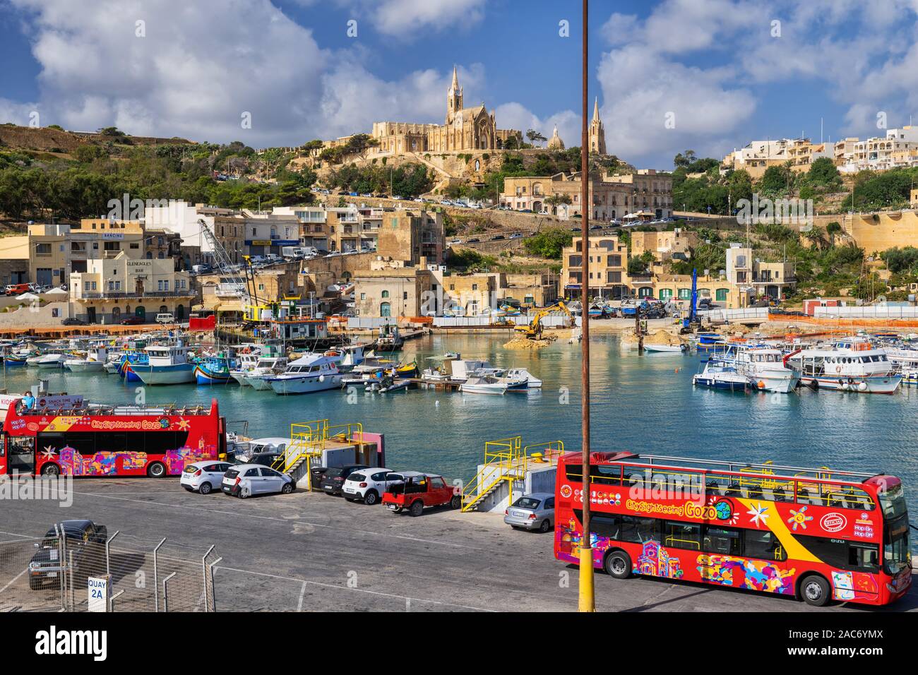Ville de Mgarr avec bus visite guidée attendent les touristes au port de Gozo, région du nord de Malte, une île de la Mer Méditerranée Banque D'Images